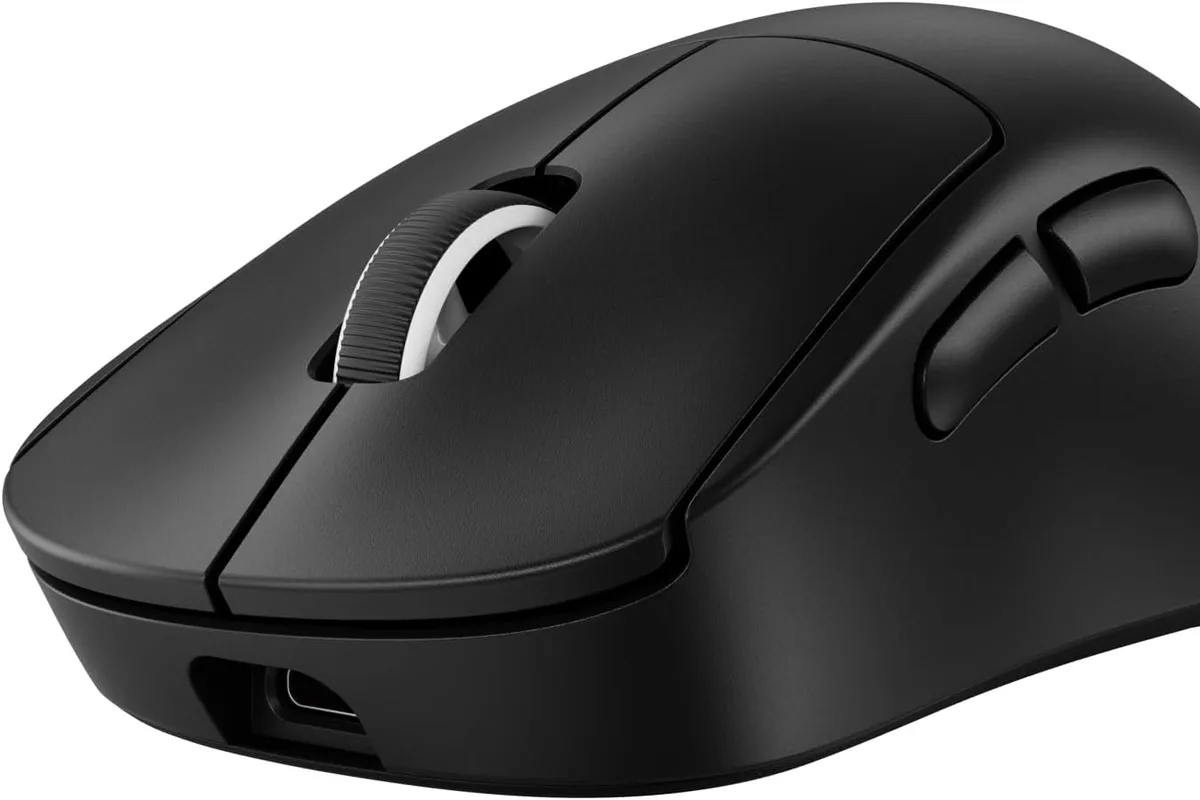 A lightweight wireless gaming mouse on a mousepad next to a keyboard