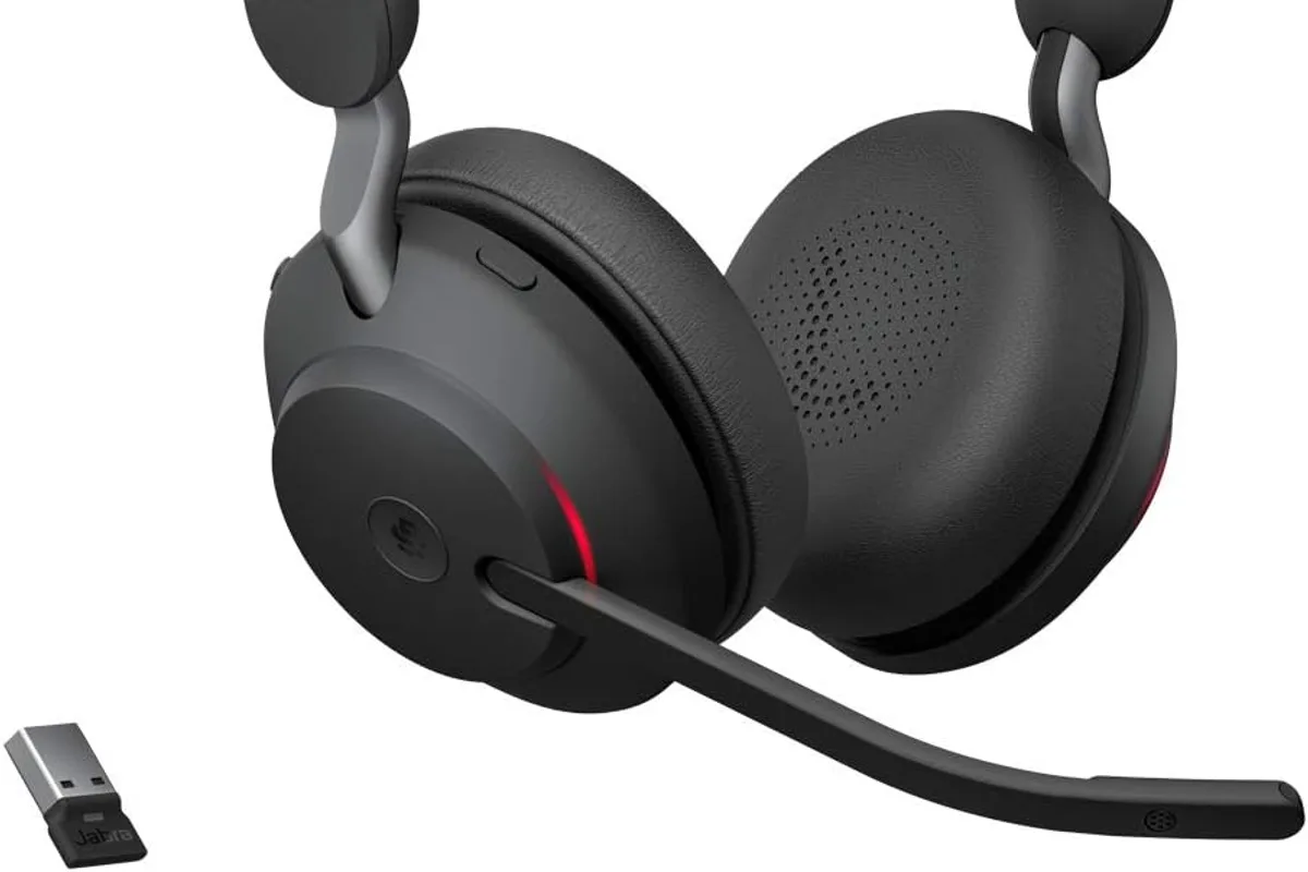 A professional headset on a desk with a laptop in a video call