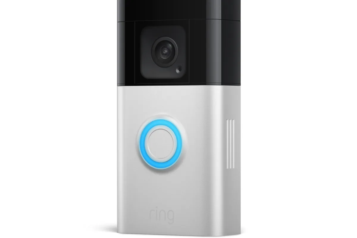 A video doorbell installed beside a front door with a door mat below