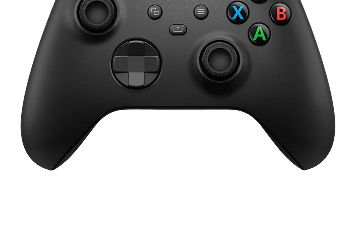 A wireless gaming controller on a coffee table next to a game console